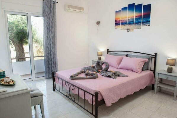 A bedroom with a bed, bedside tables, a desk, and a window with curtains.