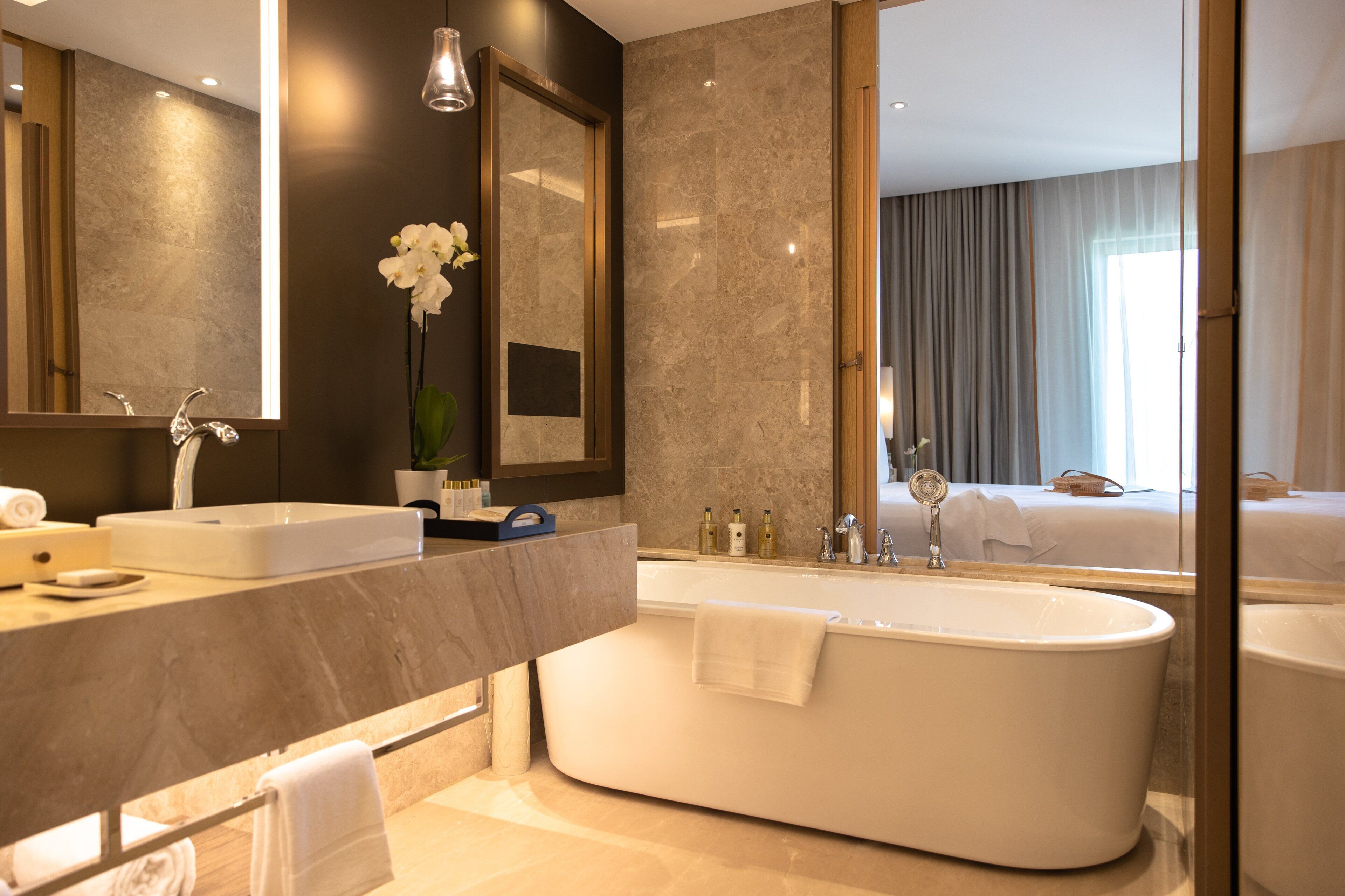 Un bagno moderno con una vasca freestanding, un ampio specchio e un lavabo con mobile.