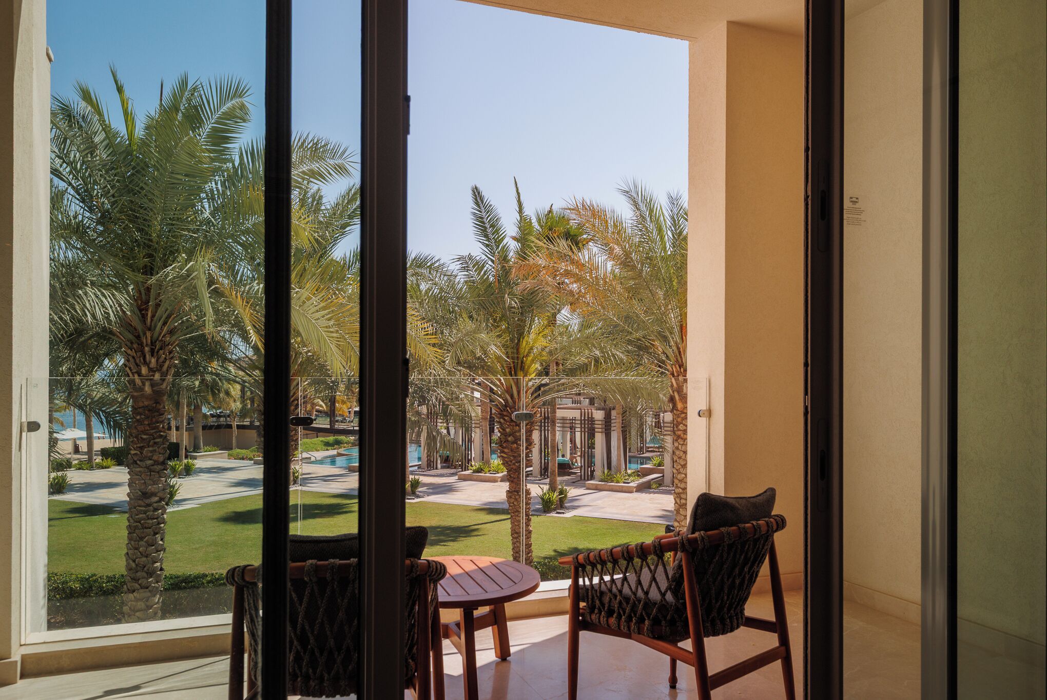Un balcón con vista a una piscina y palmeras.