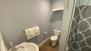Un baño con lavamanos, inodoro y toallero.