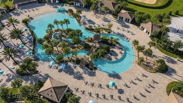 Vista aérea de un resort con una gran piscina, zonas de descanso y palmeras.