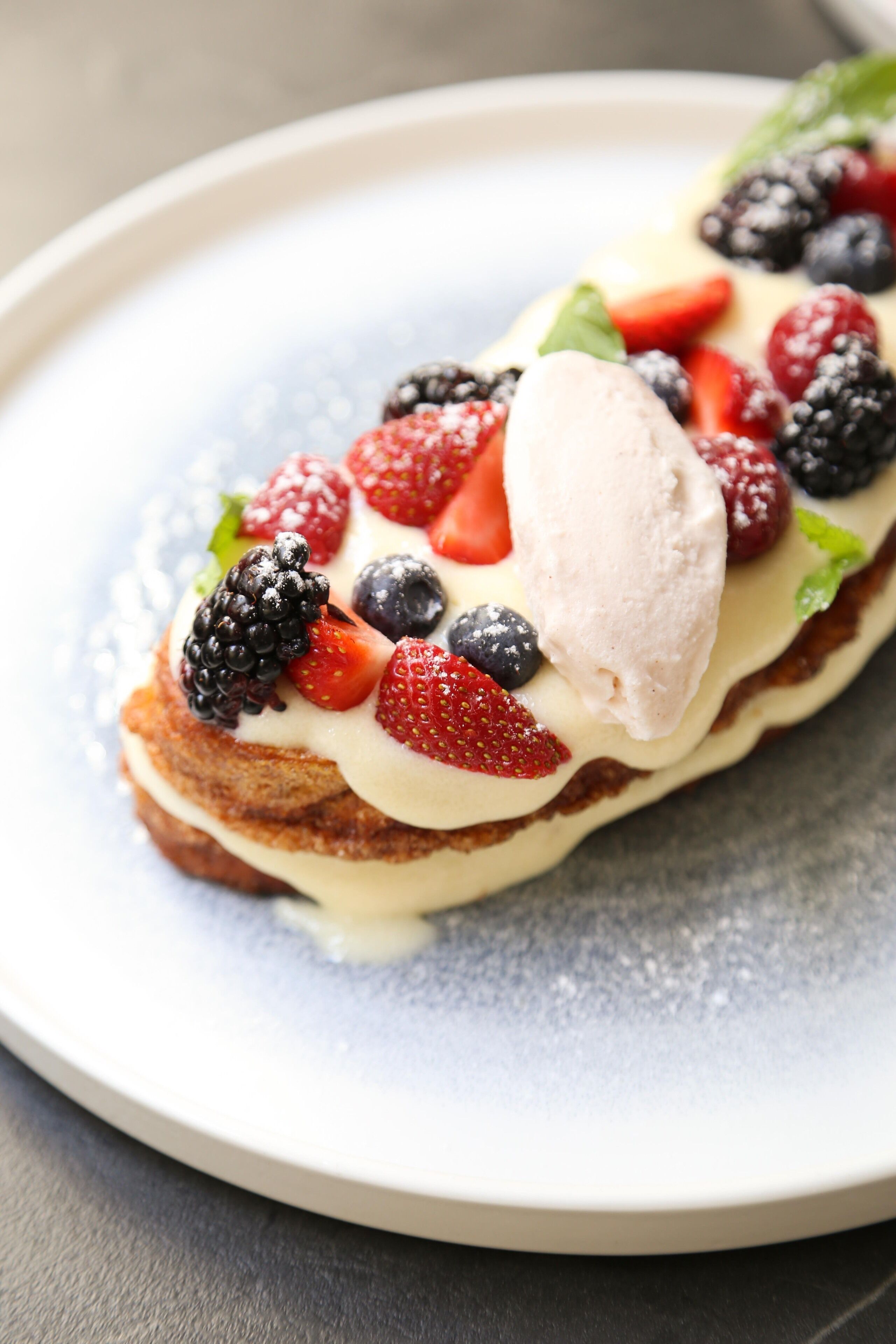 A dessert with berries and ice cream on a plate.