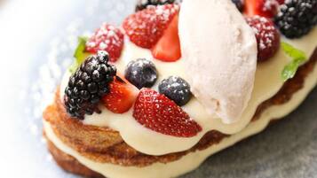 A dessert with berries and ice cream on a plate.
