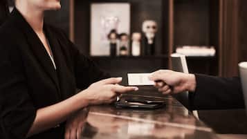 A person handing over a card to another at a counter.