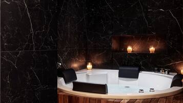 Un baño moderno con una bañera independiente, paneles de madera y paredes de mármol.