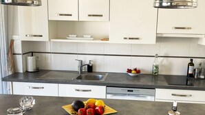 A modern kitchen with white cabinets, a black countertop, and stainless steel appliances. - Lovely and bright apartment on the fifth floor with a large terrace. Garage! (Cannes)
