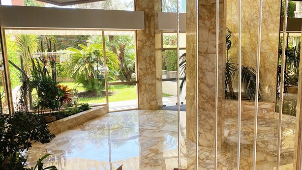 A spacious indoor area with a marble floor, a pool, and a view of a lush garden. - Lovely and bright apartment on the fifth floor with a large terrace. Garage! (Cannes)
