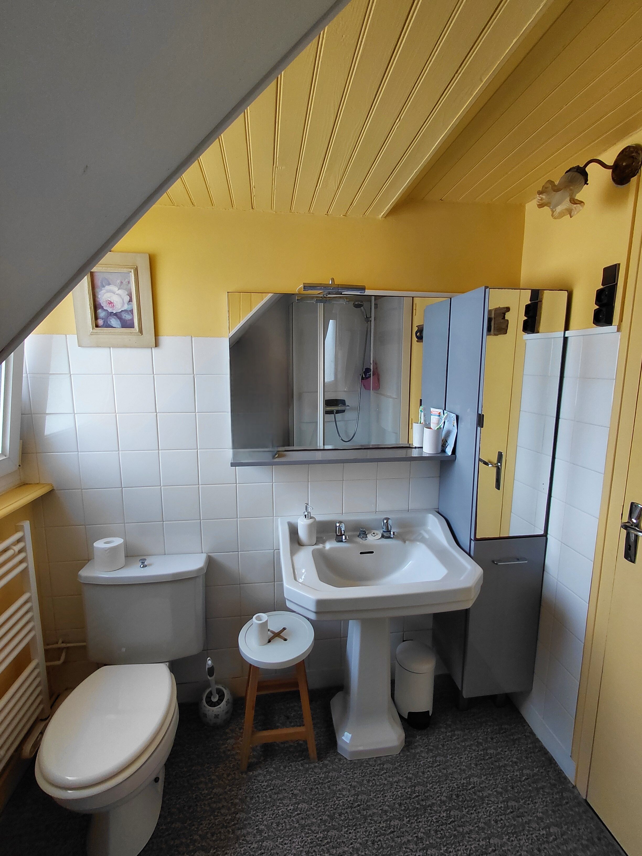 A compact bathroom with a toilet, sink, and mirror.