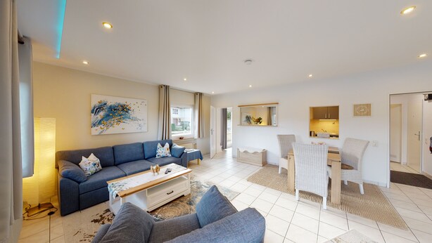 A modern living room with a sofa, coffee table, and a dining area with chairs and a table. - Vacation apartment in the Harz Mountains - Schulenberg (Schulenberg im Oberharz)