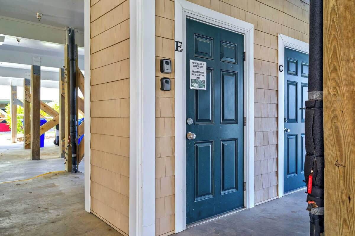 A building with two doors labeled 'E' and 'C', a wooden exterior, and a covered entrance area.