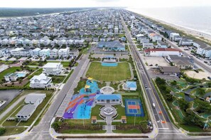 An aerial view of a residential area with houses, a road, and a playground.