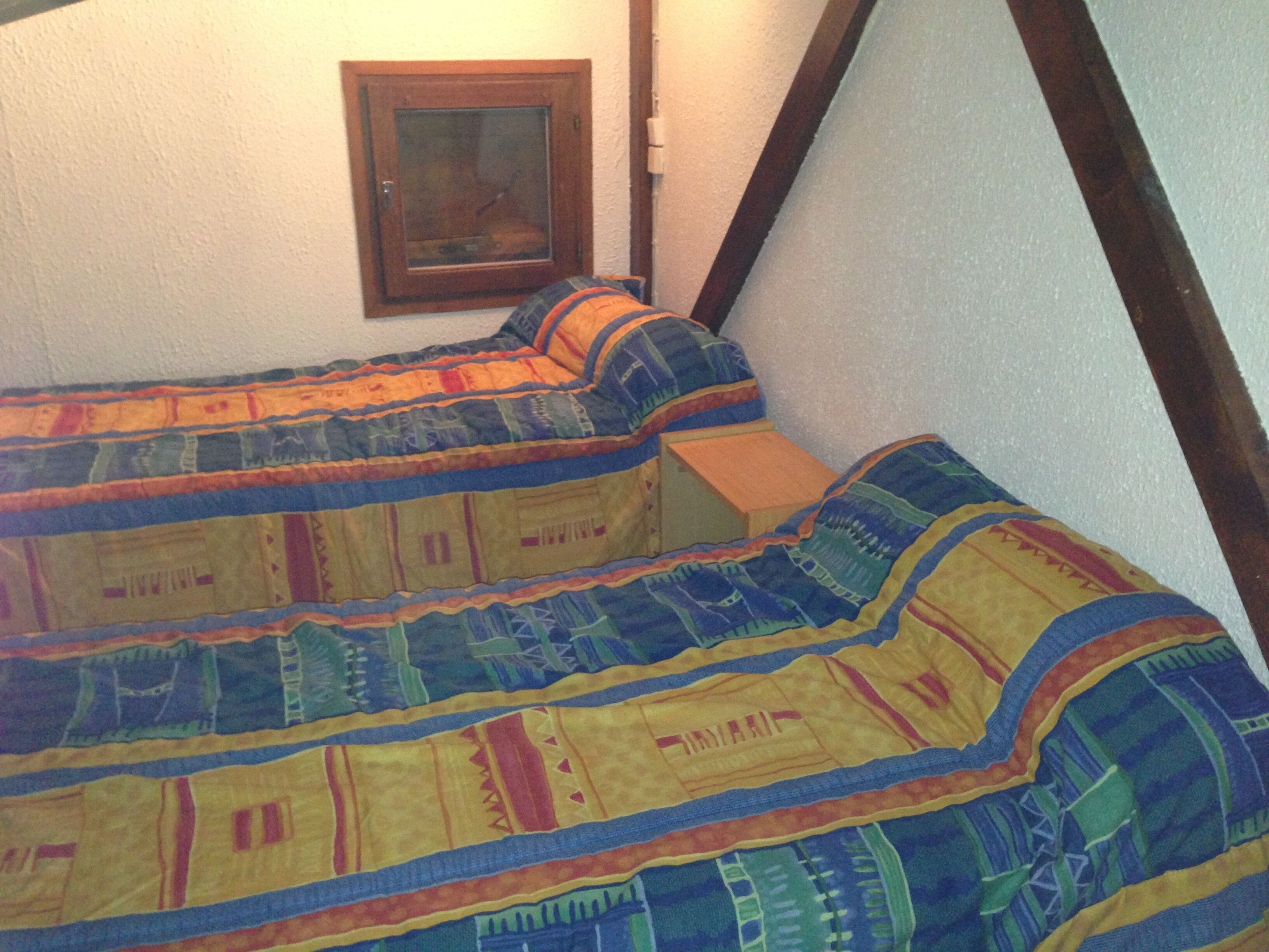 Una camera da letto con un letto grande ricoperto da una coperta colorata.
