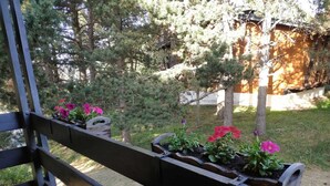 A wooden deck with planters containing pink flowers. - Chalet en Bois Dans Clairière à Pyrénées 2000 (Bolquère)