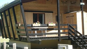 A wooden cabin with a porch, a staircase, and flower boxes. - Chalet en Bois Dans Clairière à Pyrénées 2000 (Bolquère)