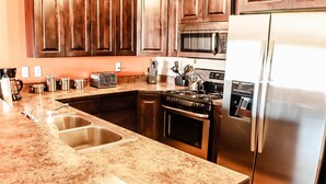 A kitchen with granite countertops, stainless steel appliances, and wooden cabinets. - Desert Willow Rim Vista 6A7 (Moab)