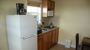 A compact kitchen with a refrigerator, microwave, kettle, and sink. - Private One Bedroom Cottage- Bonefish Creek (Barretarre)