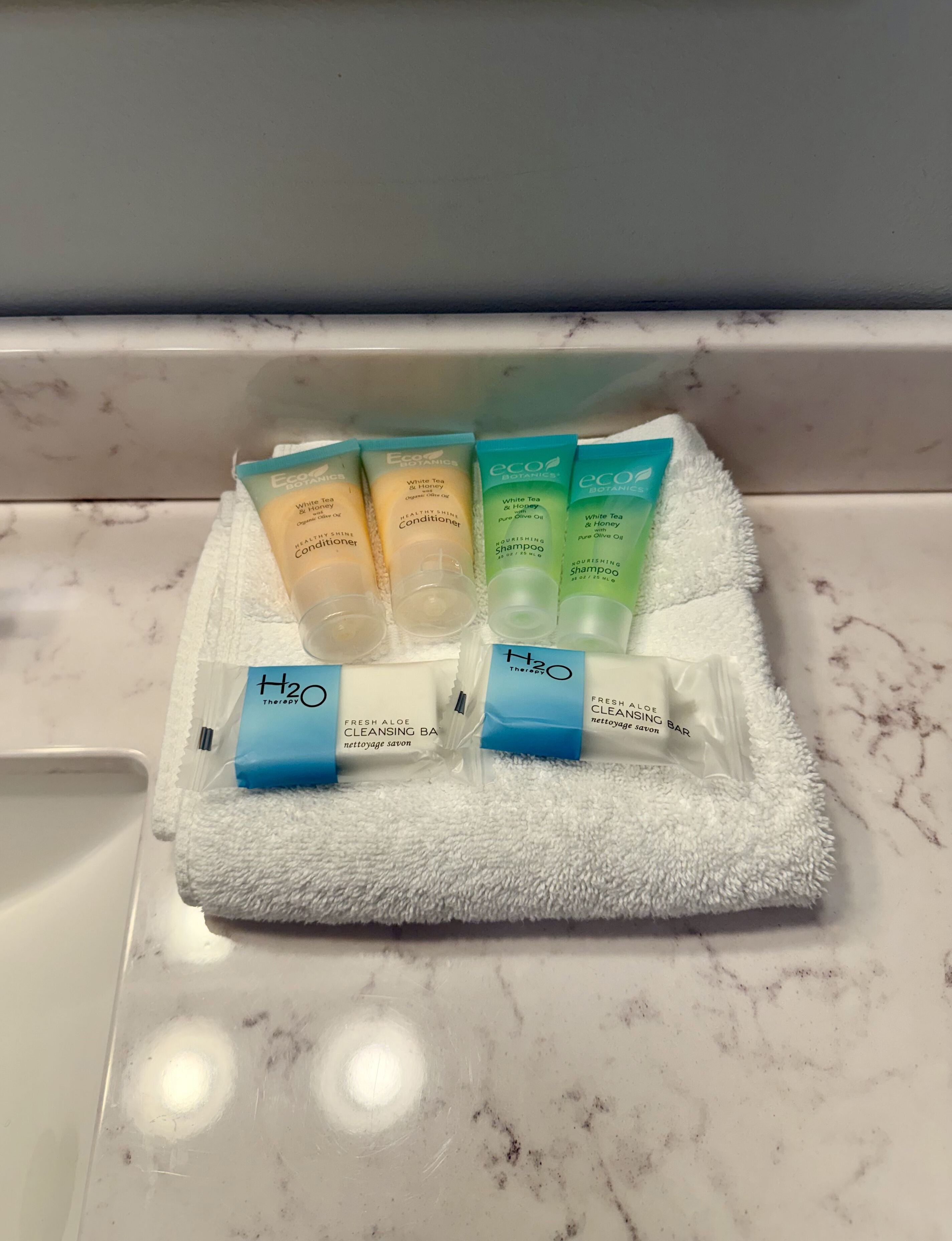 Ein Badezimmer mit einem weißen Handtuch und Toilettenartikeln auf einer Marmorplatte.