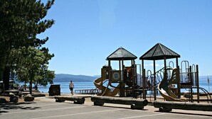 A playground with slides and climbing structures near a body of water. - Quiet & Large house - Hot Tub, Pool table, Fast WiFi  -  close to Kings Beach! (Tahoe Vista)
