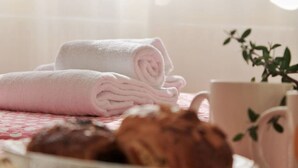 A neatly folded towel, a cup, and a plate with pastries on a table. - Espacioso apartamento - El Nido de Ris 6918 (Noja)