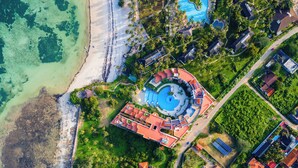 An aerial view of a resort with a central swimming pool, beachfront, and lush greenery. - Kilua Residences by CityBlue, Mombasa (Mombasa)