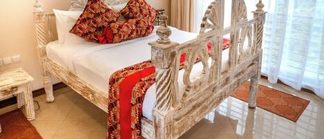Un espacioso dormitorio con cama con dosel, un candelabro y vistas de la ciudad a través de amplias ventanas.