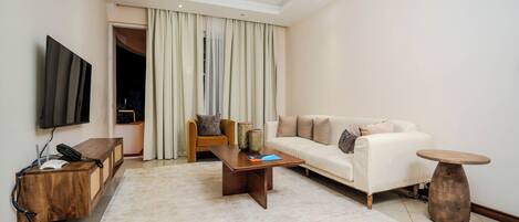 A modern living room with a sofa, coffee table, and TV.