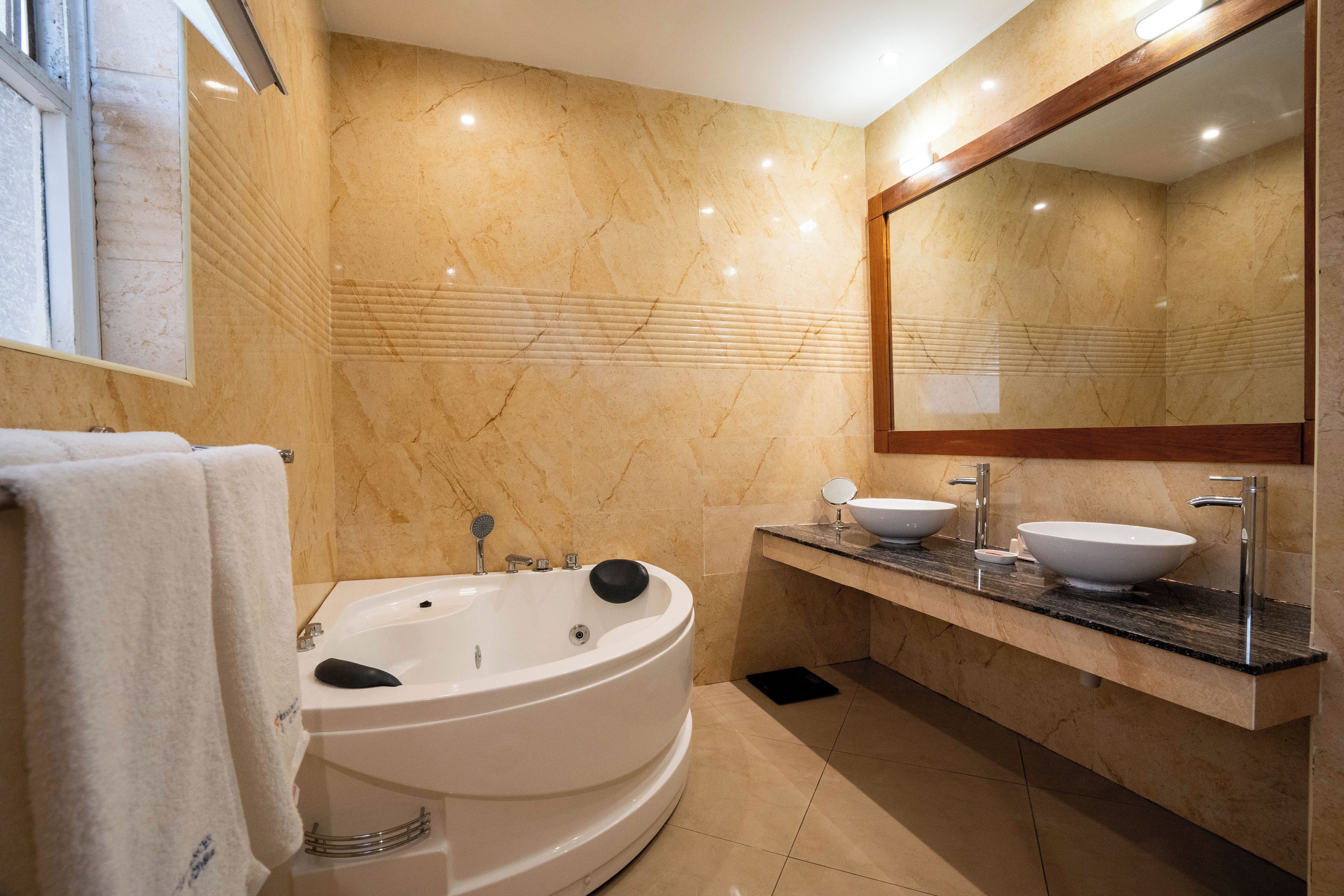 Un bagno moderno con una vasca freestanding, due lavabi e un ampio specchio.