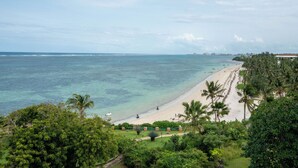 A beach with clear turquoise water, palm trees, and a distant city skyline. - Kilua Residences by CityBlue, Mombasa (Mombasa)