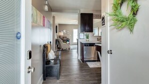 A modern kitchen with dark cabinets, a dishwasher, and a green plant. - The Lofts of Downtown (540 N 2nd St, #211) (Clarksville)