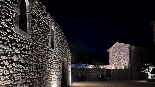 Ein Gebäude aus Stein mit Innenhof bei Nacht.