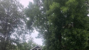 A two-story house with a front porch, a red door, and a small front yard. - Twin Porch Retreat (Cambridge)