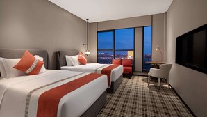 A hotel room with two beds, a sofa, a TV, and a city view. - Ramada Plaza by Wyndham Xiangtan Wanlou (Xiangtan)
