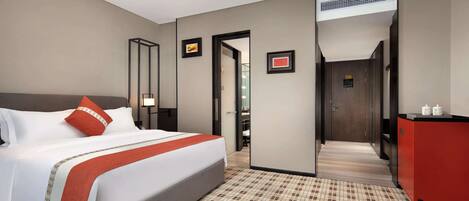 A hotel room with a large bed, a red cabinet, and a tiled floor.