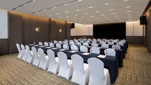 A conference room with rows of tables and chairs, equipped with water bottles and name cards. - Ramada Plaza by Wyndham Xiangtan Wanlou (Xiangtan)