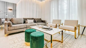 Uma sala de estar moderna com um sofá, poltronas, uma mesa de centro e um tapete.