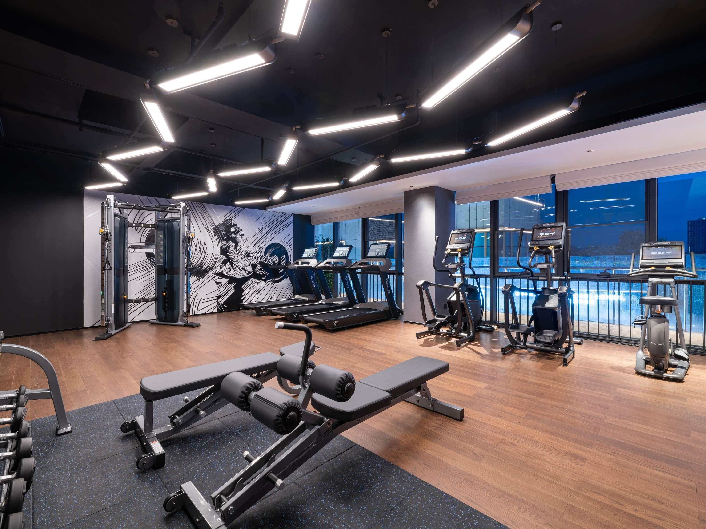 A gym with treadmills, elliptical machines, and weightlifting equipment.