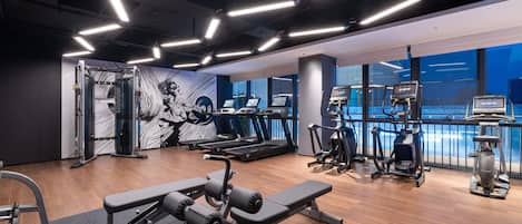 A gym with treadmills, elliptical machines, and weightlifting equipment.