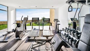 A gym with treadmills, stationary bikes, and a weight rack.