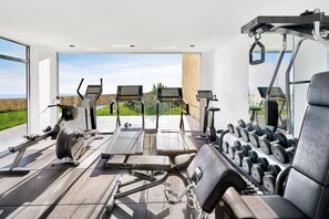 Una palestra con tapis roulant, cyclette e una rastrelliera per pesi.