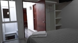 Una camera da letto con un letto, un armadio e una porta che dà sul bagno.