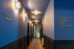 A hallway with directional signs to lobby, Casa A, and the gym. - HAB Hotel (Bogotá)