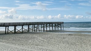 A beach with a wooden pier extending into the ocean. - Beach Getaway: Stunning, Family-Friendly w/ Pool. Walk to Shopping + Dining (Atlantic Beach)