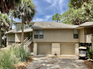 A two-story house with a garage, a covered porch, and a small lawn.