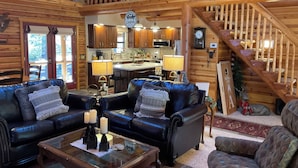 A cabin interior with a living room, kitchen, and staircase. - Luxury Log Cabin Living! AC, Kid & Pet Friendly, Fishing, Hiking, Golf (Pinetop)