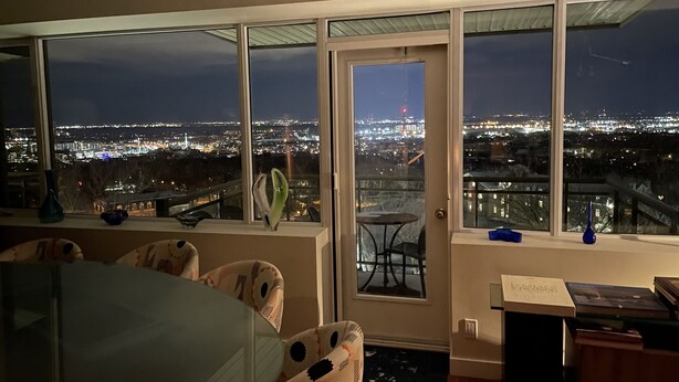 Una habitación con un amplio ventanal que da a una vista nocturna de la ciudad.