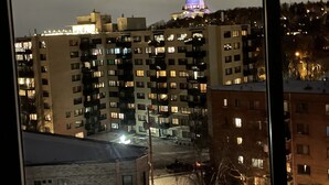 Un edificio de varios pisos con una estructura cúpula destacada en la parte superior, que incluye una cúpula iluminada y un asta de bandera.