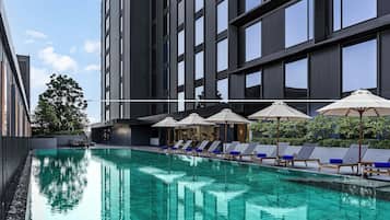 Una piscina al aire libre, sillones reclinables de piscina