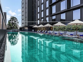 Una piscina al aire libre, sillones reclinables de piscina