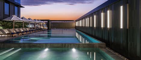 Una piscina al aire libre, tumbonas