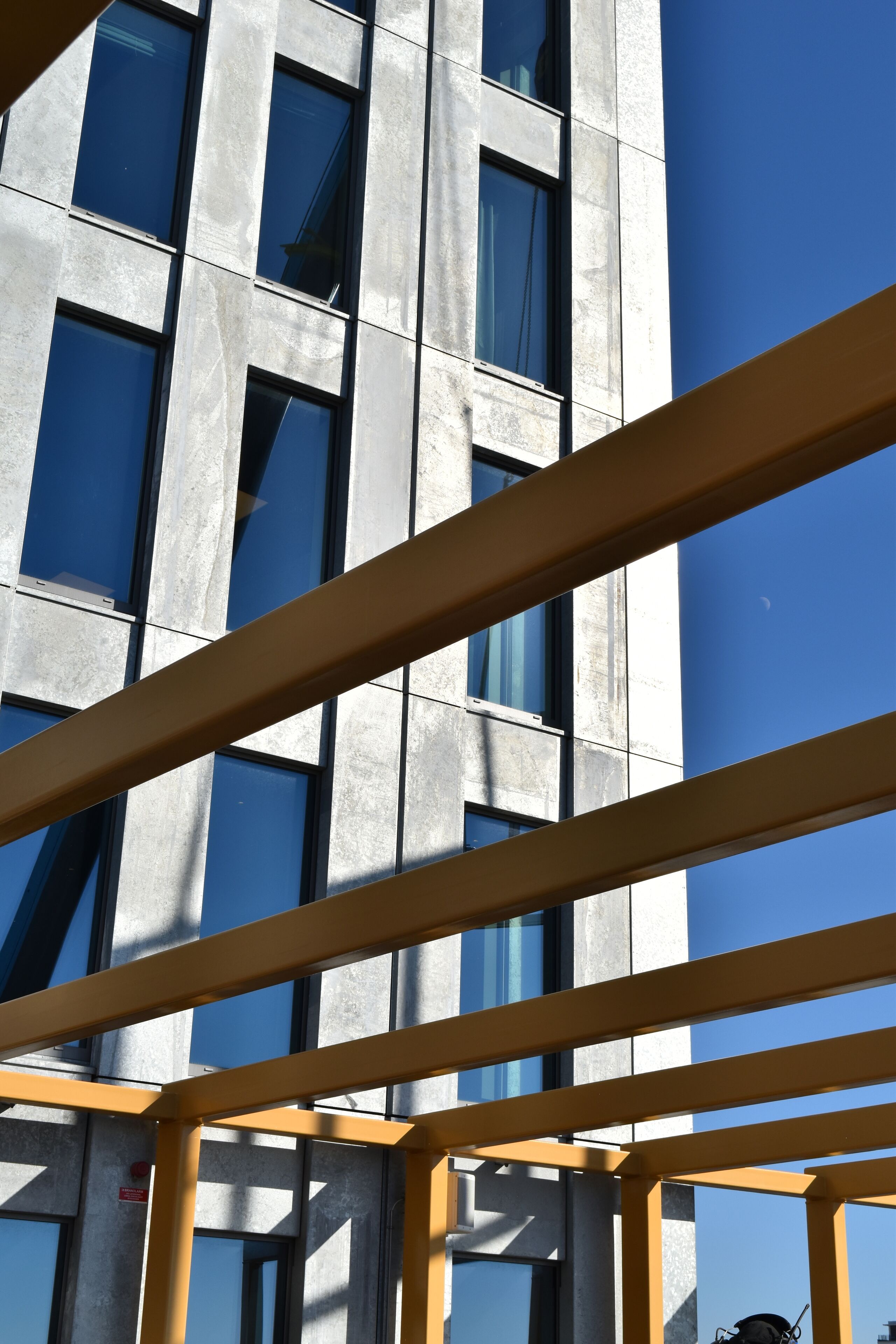 Ein modernes Gebäude mit großen Fenstern und einem gelben Metallgerüst.